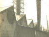 two-metal-chimneys-left-chimney-has-scaffolding-with-3-workers-and-1-worker-in-wagon
