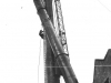 two-metal-chimneys-one-at-an-angle-metal-mast-in-background-with-1-worker-up-gantry