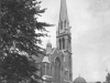 large-church-with-spire-scaffolding-workers-at-top-of-spire